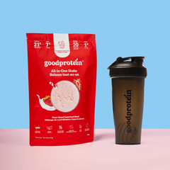 Good Protein Strawberries & Cream All-in-One Shake pouch with black shaker bottle on a pink backdrop, ready for easy mixing.